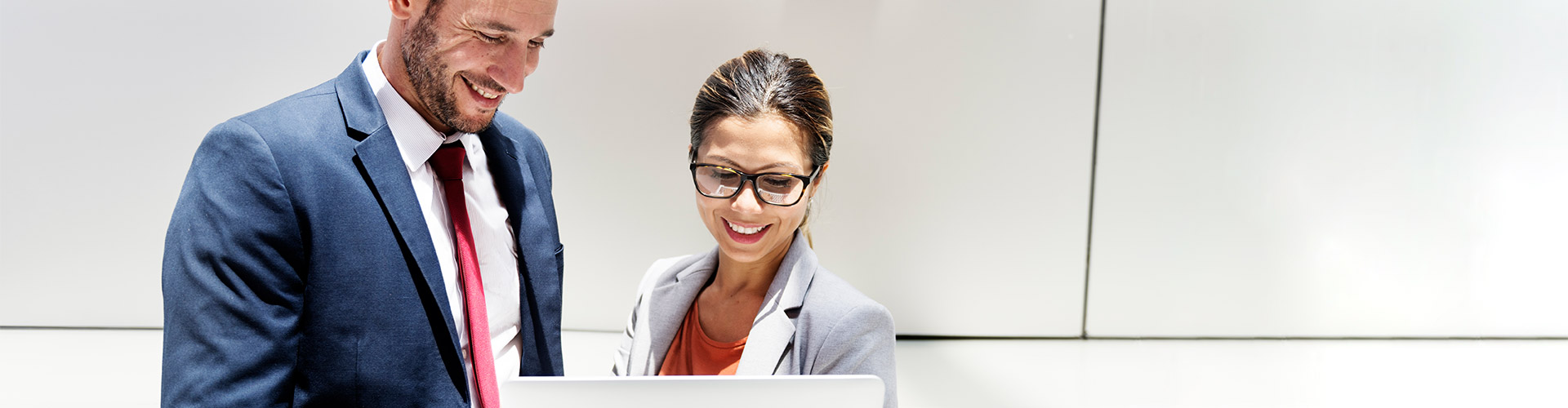 Financiacion de Impuestos y Seguros Sociales - Hombre y mujer de negocios con traje y corbata mirando una tablet y hablando de negocios y financiacion de empresas