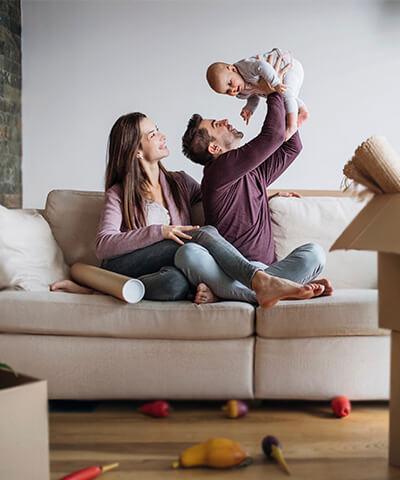 Ventajas para Particulares - Una pareja con su hijo, felices, haciendo la mudanza a su nueva casa